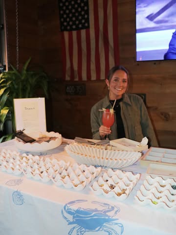 Cocktails for a Cause — a girl holding a cocktails at a table